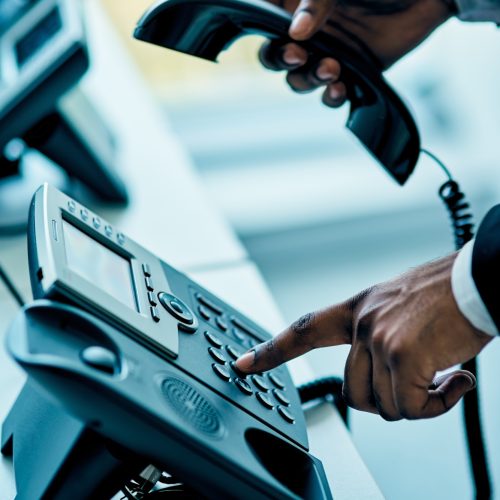 Closeup shot of unrecognizable businessman using a telephone in an office Closeup shot of unrecognizable businessman using a telephone in an office